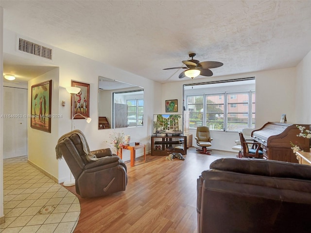 living room featuring light hardwood / wood-style floors and ceiling fan