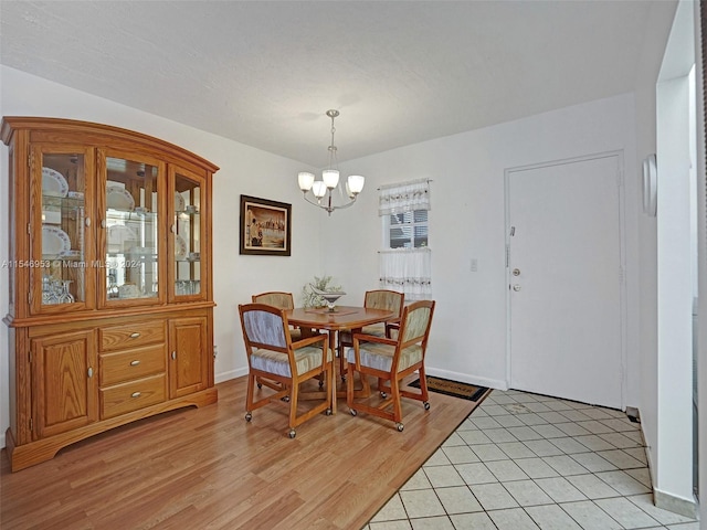 dining space with a chandelier and light hardwood / wood-style flooring