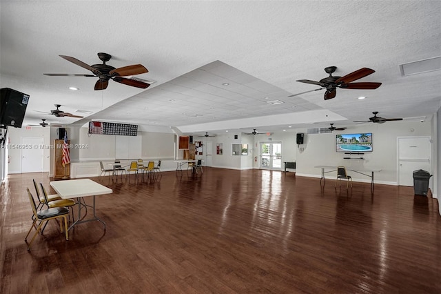 interior space featuring a textured ceiling, ceiling fan, and dark wood-type flooring