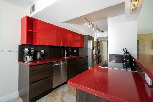 kitchen with stainless steel appliances, light tile floors, rail lighting, backsplash, and sink