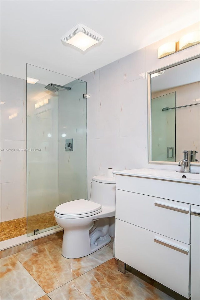 bathroom with toilet, vanity with extensive cabinet space, tile floors, and a shower with shower door