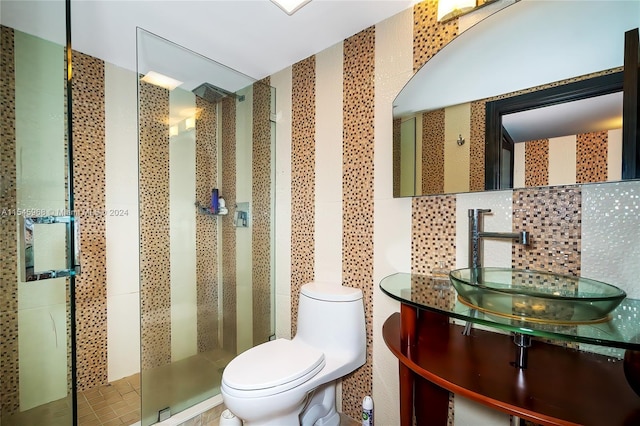 bathroom featuring tile walls, toilet, a shower with door, tasteful backsplash, and vanity