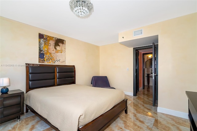 bedroom featuring light tile flooring and a notable chandelier