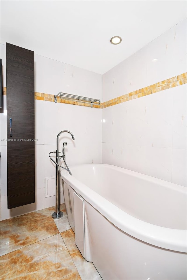 bathroom with tile walls, tile floors, and a washtub