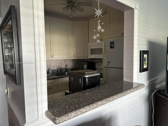 kitchen with kitchen peninsula, ceiling fan, sink, and white appliances