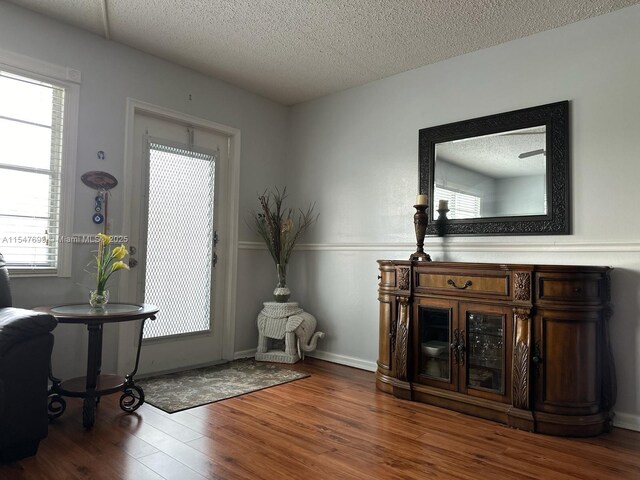 interior space with hardwood / wood-style flooring, a healthy amount of sunlight, and a textured ceiling