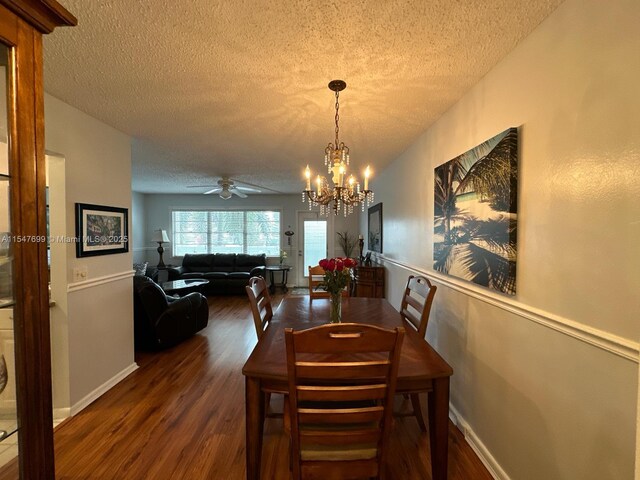 dining room featuring ceiling fan with notable chandelier, dark hardwood / wood-style flooring, and a textured ceiling