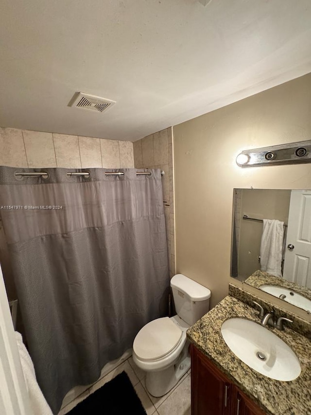 bathroom with tile floors, vanity with extensive cabinet space, and toilet