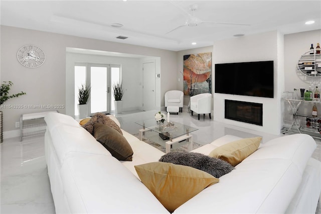 living room featuring ceiling fan, french doors, and a fireplace