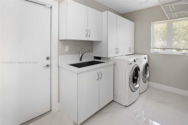 laundry area featuring cabinets, washing machine and clothes dryer, and sink