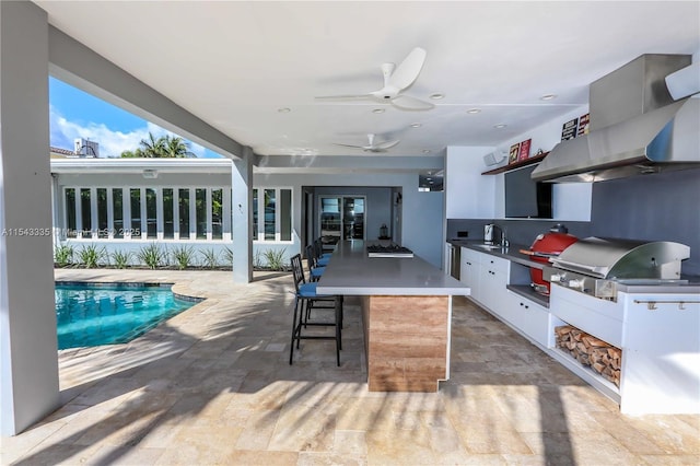 view of patio featuring grilling area, ceiling fan, area for grilling, and an outdoor wet bar