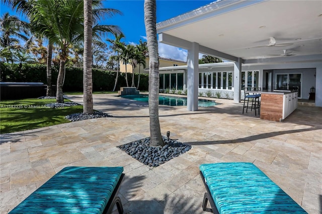 view of patio featuring ceiling fan and exterior bar