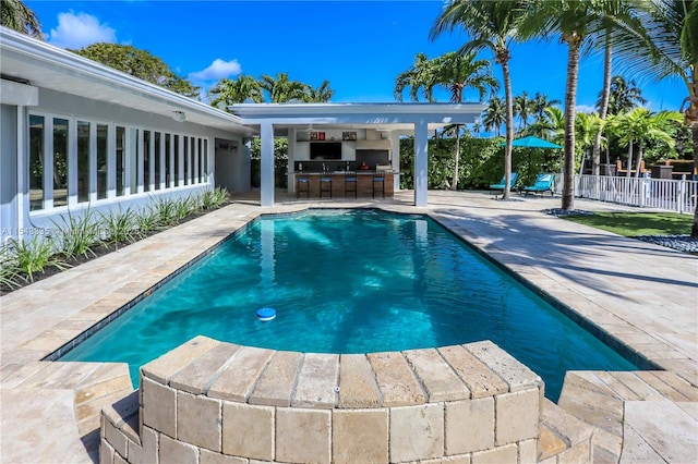 view of swimming pool featuring a patio and an outdoor bar