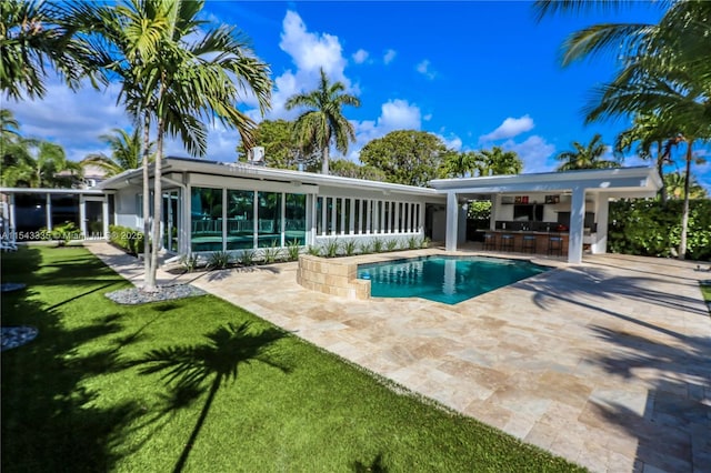 view of pool featuring a patio area, a yard, and exterior bar