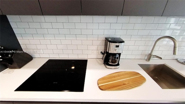 details with stovetop, backsplash, and sink