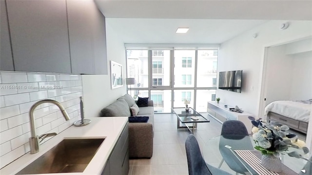 living room with light tile patterned flooring, expansive windows, and sink