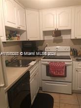 kitchen featuring black dishwasher, stove, white cabinetry, and sink