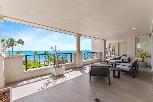 view of patio featuring a balcony and a water view