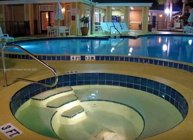 view of swimming pool with an indoor hot tub