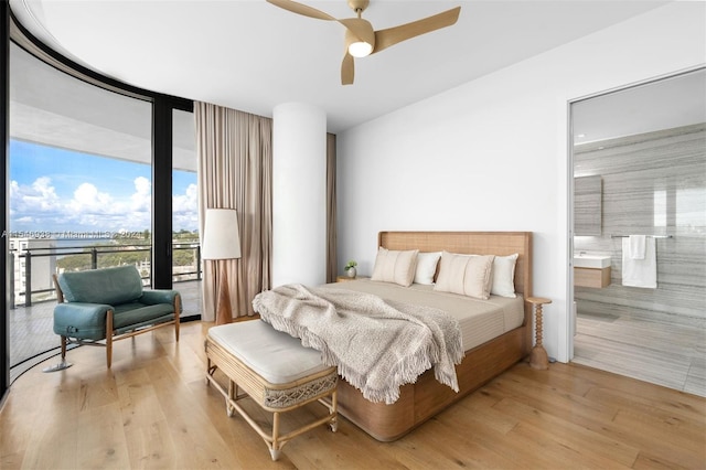 bedroom featuring ceiling fan, light hardwood / wood-style flooring, and ensuite bath