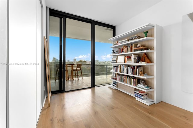 doorway to outside with light wood-type flooring and floor to ceiling windows