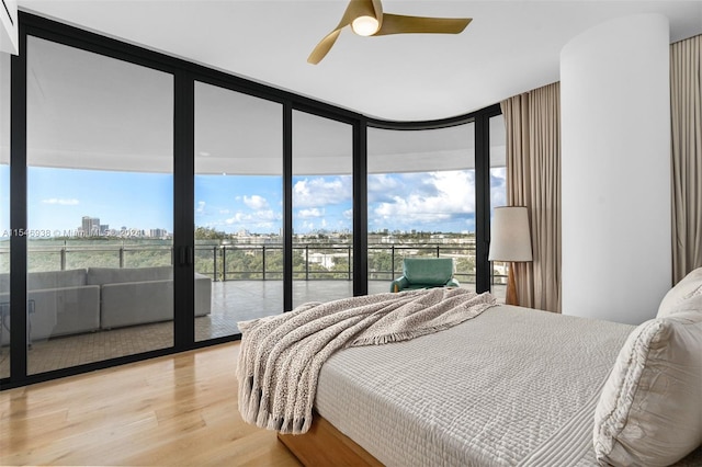 bedroom with access to exterior, floor to ceiling windows, light hardwood / wood-style flooring, and ceiling fan