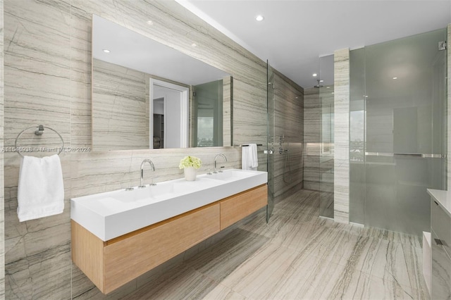 bathroom with tile walls, vanity, and a shower with door