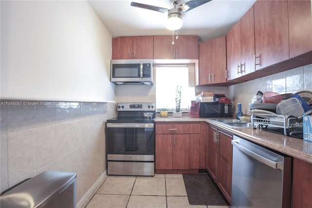 kitchen featuring ceiling fan, light tile patterned flooring, sink, and stainless steel appliances