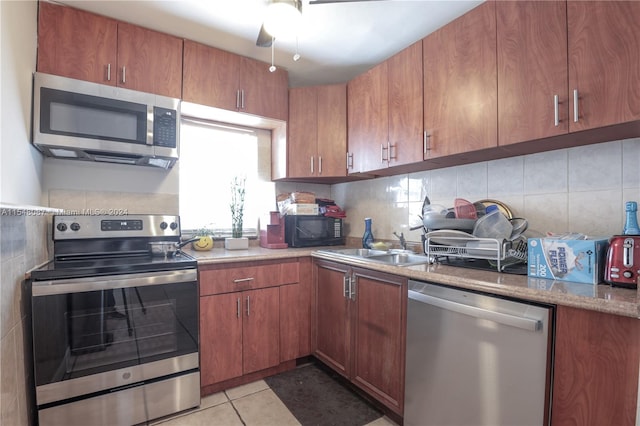 kitchen featuring decorative backsplash, appliances with stainless steel finishes, and light tile patterned flooring