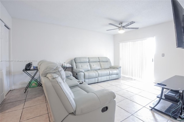 tiled living room with ceiling fan and a textured ceiling