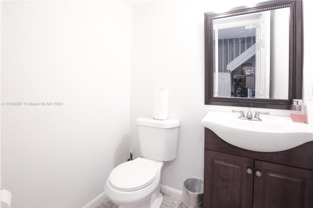 bathroom with tile patterned flooring, vanity, and toilet