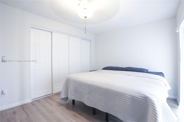 bedroom with ceiling fan, a closet, and light wood-type flooring