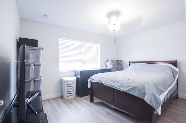 bedroom featuring light hardwood / wood-style floors and a textured ceiling