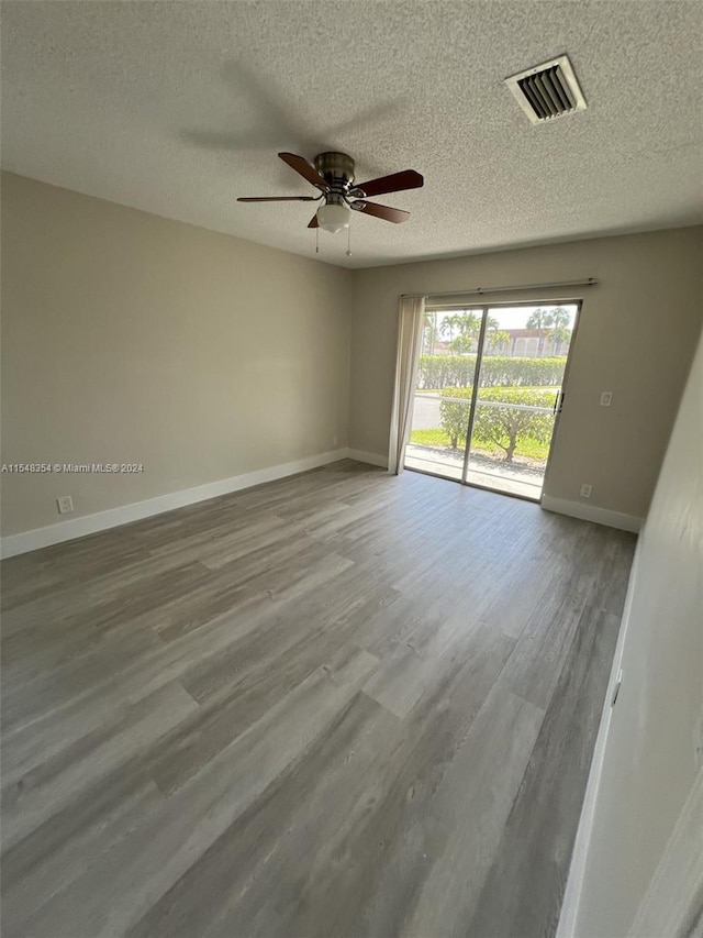 unfurnished room featuring wood-type flooring, ceiling fan, and a textured ceiling