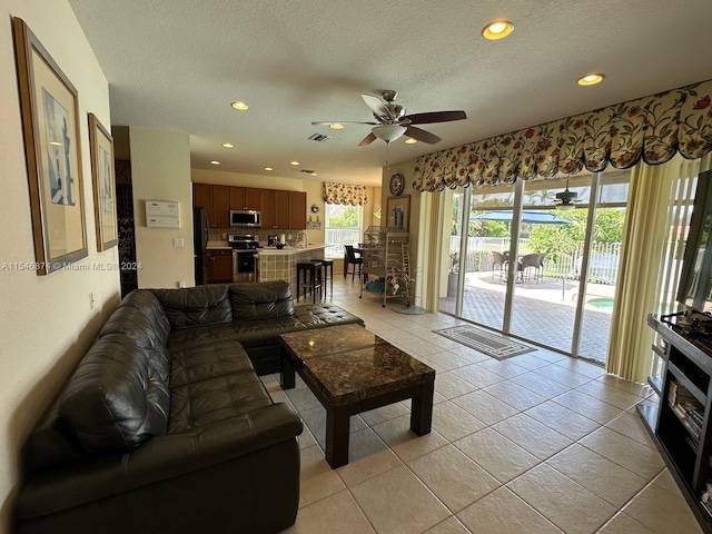 tiled living room featuring a textured ceiling and ceiling fan