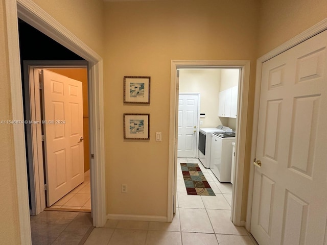 hallway with washing machine and dryer and light tile patterned floors