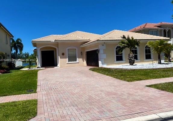 view of front of property featuring a garage and a front lawn