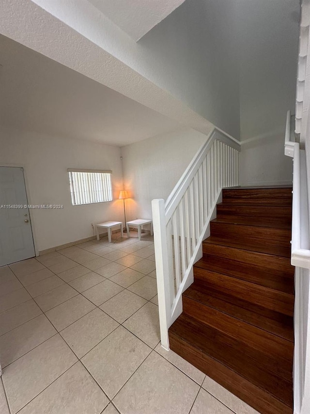 staircase featuring light tile floors