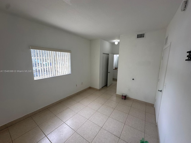 unfurnished room featuring light tile floors