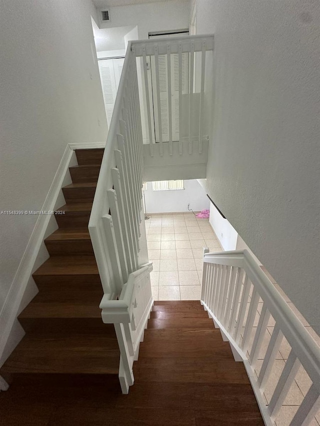 stairs with dark hardwood / wood-style flooring