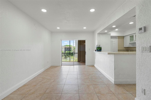 empty room featuring light tile floors and a textured ceiling