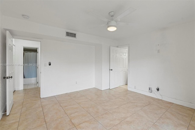 unfurnished room with ceiling fan and light tile floors