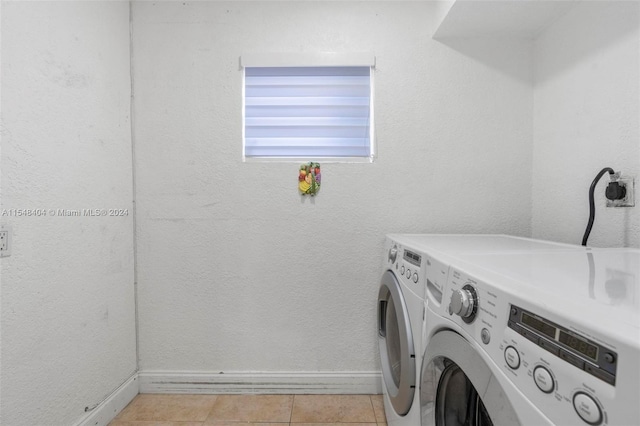 laundry area featuring light tile flooring, electric dryer hookup, and washing machine and clothes dryer