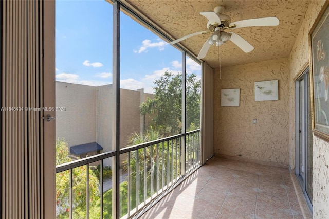 unfurnished sunroom featuring ceiling fan