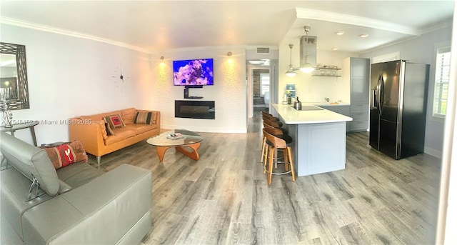 living room featuring light wood-type flooring and ornamental molding