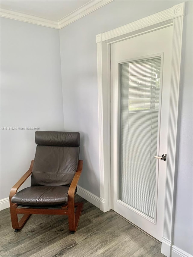 sitting room with hardwood / wood-style flooring and ornamental molding