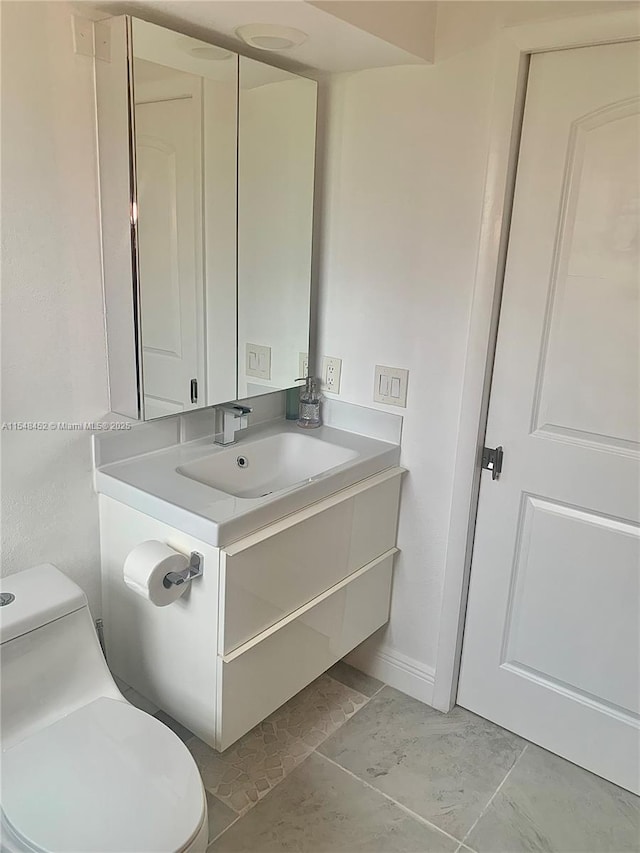 bathroom with tile patterned floors, vanity, and toilet