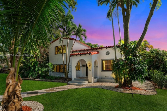 mediterranean / spanish house featuring a yard