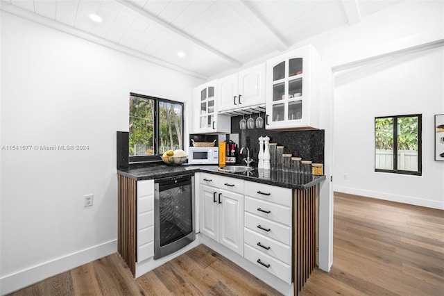 kitchen featuring white cabinets, backsplash, sink, and light hardwood / wood-style flooring