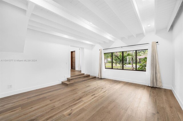 spare room with wood-type flooring and beam ceiling